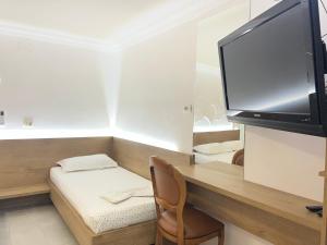 a room with a desk with a tv and a chair at Guest House Kasa Garden in Durrës
