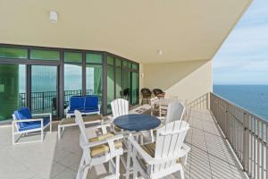 a balcony with a table and chairs and the ocean at Phoenix West 2601 in Orange Beach
