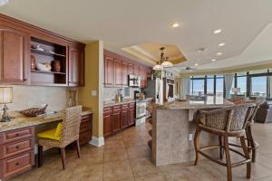 a large kitchen with wooden cabinets and a large island at Phoenix West 2601 in Orange Beach +49 photos