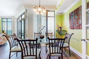 a dining room with a glass table and chairs at Phoenix West 502 in Orange Beach