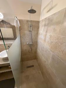 a shower with a glass door in a bathroom at Mas des Fleurs in Châteaurenard