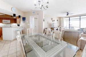 a kitchen and a living room with a glass table at Pelican Pointe 302 in Orange Beach