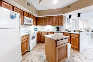 a kitchen with wooden cabinets and a white refrigerator at Pelican Pointe 302 in Orange Beach +28 photos