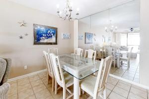 a dining room with a glass table and chairs at Pelican Pointe 302 in Orange Beach