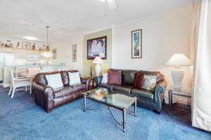 a living room with two leather couches and a table at Regency Isle 805 in Orange Beach