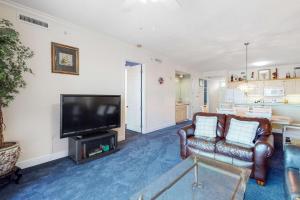 a living room with couches and a flat screen tv at Regency Isle 805 in Orange Beach