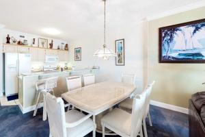 a kitchen and dining room with a table and chairs at Regency Isle 805 in Orange Beach