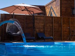 a swimming pool with an umbrella and two chairs and a swimming pool at Villa Maris in Demre
