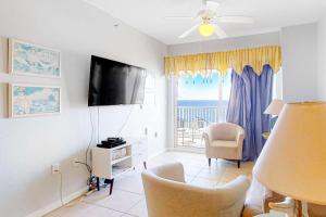 a living room with a flat screen tv and a window at Tidewater 908 in Orange Beach