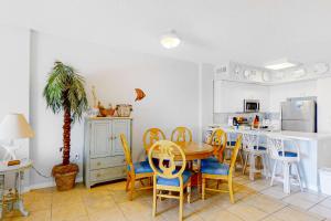 a kitchen with a table and chairs and a dining room at Tidewater 908 in Orange Beach