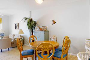a dining room with a wooden table and chairs at Tidewater 908 in Orange Beach +24 photos