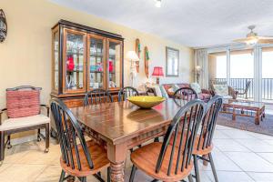 a dining room with a wooden table and chairs at Wind Drift 311S in Orange Beach