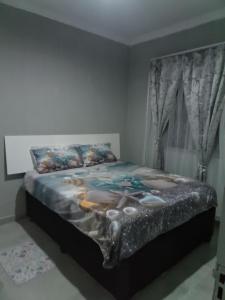 a bedroom with a large bed in a room at Cozy suburban guest house - Durban in Verulam