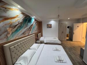 a hotel room with two beds and a painting on the wall at Vila Silvi Bala in Pilur +23 photos