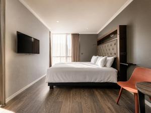 a hotel room with a bed and a television at ASKA Holt in Reykjavík