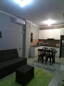 a living room with a couch and a table and chairs at Cozy suburban guest house - Durban in Verulam
