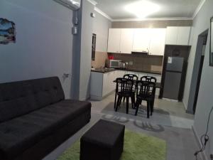 a living room with a couch and chairs and a kitchen at Cozy suburban guest house - Durban in Verulam +6 photos