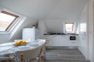 a white kitchen with a table with fruit on it at A Casita do Muelle in Cambados