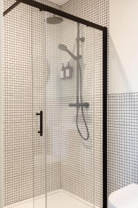 a shower with a glass door next to a toilet at Check In Belfast in Belfast