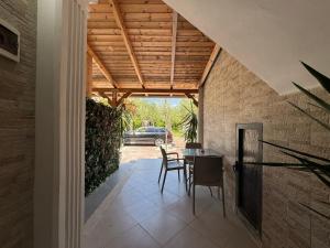 a patio with a table and chairs in a house at Guest House Kasa Garden in Durrës