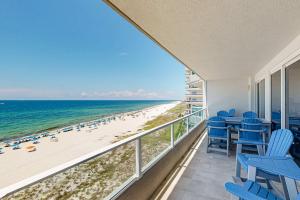 a balcony with blue chairs and a view of the beach at Silver Beach 601 in Orange Beach