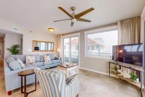 a living room with a couch and a tv at Silver Beach 601 in Orange Beach