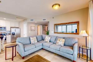 a living room with a blue couch and a kitchen at Silver Beach 601 in Orange Beach