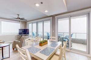 a dining room with a table and chairs and windows at Silver Beach 601 in Orange Beach +22 photos
