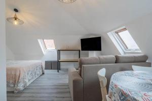 a living room with a couch and a tv at A Casita do Muelle in Cambados