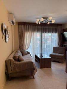 a living room with a couch and a table at Peralun Lux Apartments in Nea Peramos