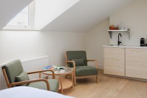 a room with two chairs and a table and a kitchen at Check In Belfast in Belfast