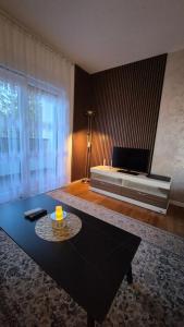 a living room with a coffee table and a bed at Trebevic Skyline Apartman in Dovlići