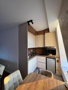 a kitchen with a table and chairs in a room at Trebevic Skyline Apartman in Dovlići +14 photos