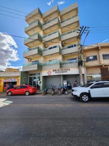 a building with cars parked in front of it at Isa Flats in Janaúba