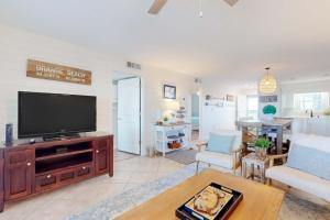 a living room with a flat screen tv on a wooden entertainment center at Jubilee Landing 302 in Orange Beach