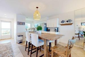 a kitchen and dining room with a wooden table and chairs at Jubilee Landing 302 in Orange Beach