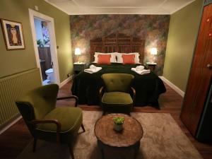 a bedroom with a bed and chairs and a table at Cruachan B & B in Tomintoul