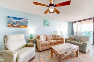 a living room with a couch and chairs and a ceiling fan at Phoenix East 702 in Orange Beach