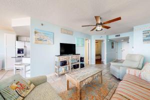a living room with a couch and a tv at Phoenix East 702 in Orange Beach
