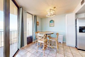 a dining room with a table and a refrigerator at Phoenix East 702 in Orange Beach +26 photos