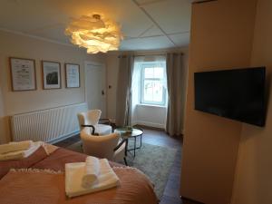 a hotel room with a bed and a flat screen tv at Cruachan B & B in Tomintoul