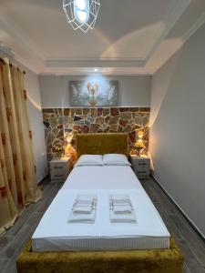 a bedroom with a bed and a stone wall at Vila Silvi Bala in Pilur