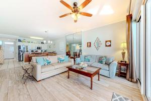 a living room with two couches and a ceiling fan at Regency Isle 611 in Orange Beach