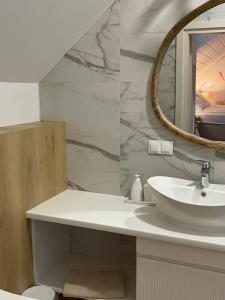 a bathroom with a sink and a mirror at Dom Gościnny Zakole in Buda Ruska +22 photos