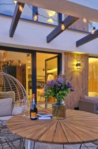 a table with a bottle of wine and flowers on it at Bosarosa Forest & Lake Villa z jacuzzi wanna SPA in Laski Małe