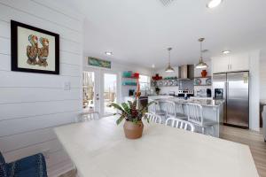 a kitchen with a white table and a kitchen with a counter at Mermaid Tales in Dauphin Island