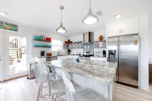 a kitchen with a large counter and a refrigerator at Mermaid Tales in Dauphin Island