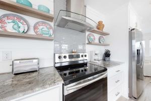 a kitchen with a stove and a refrigerator at Mermaid Tales in Dauphin Island