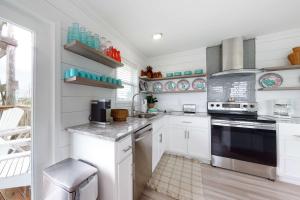 a kitchen with white cabinets and a stove top oven at Mermaid Tales in Dauphin Island