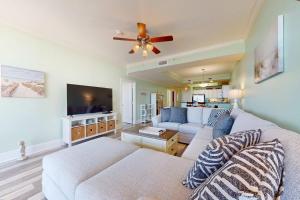 a living room with a couch and a flat screen tv at Beachfront condo with pool private balcony and laundry in Dauphin Island